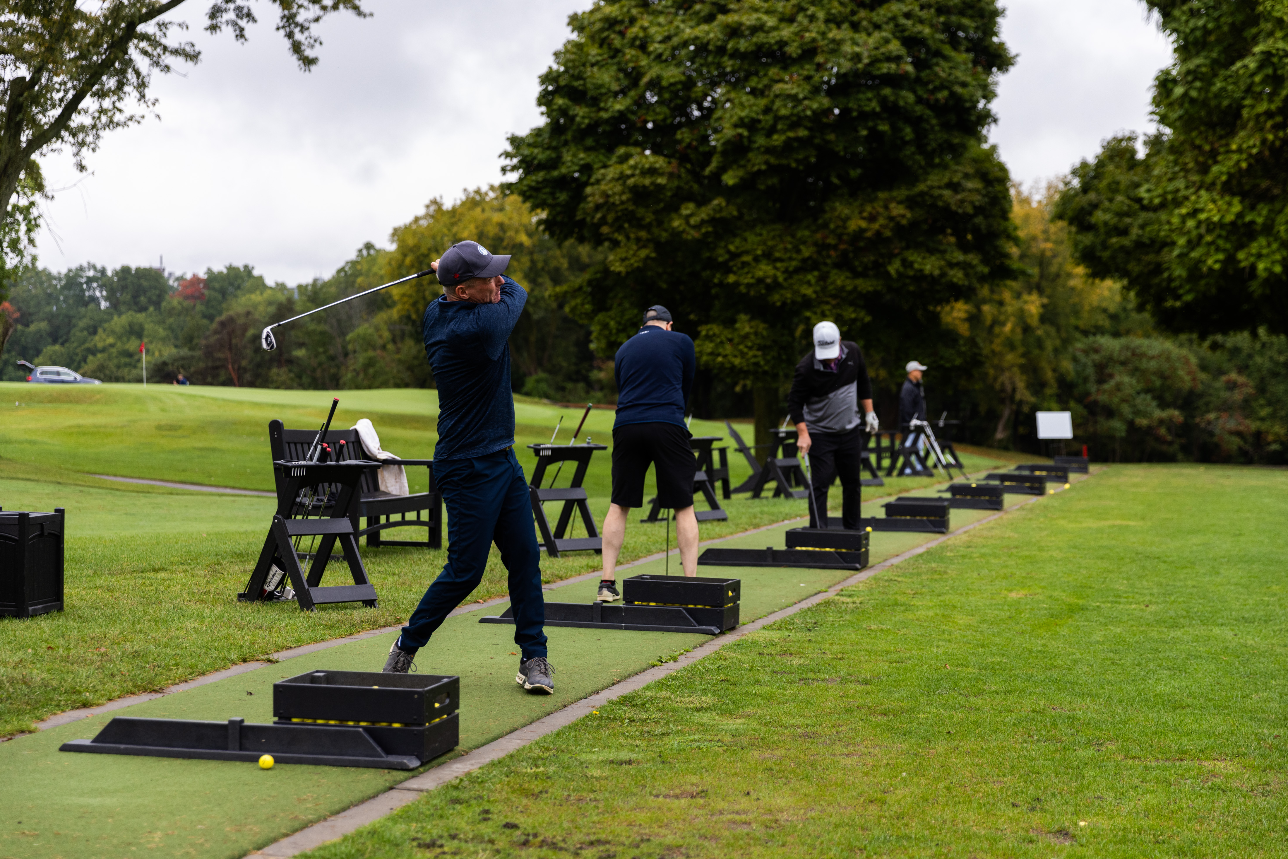 Male golfers on swinging their golf clubs on the driving range
