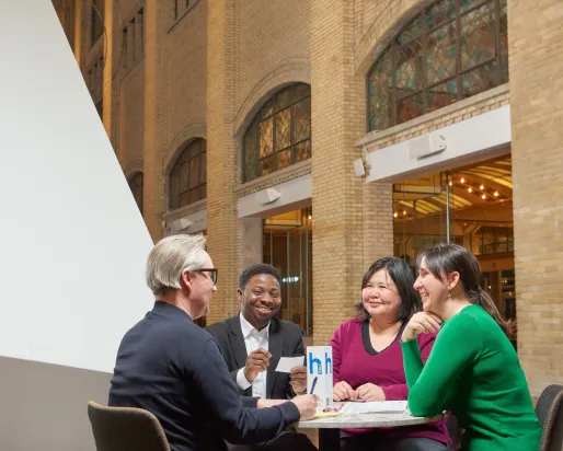 four people sitting at a table, having a fun conversation at the Royal Ontario Museum