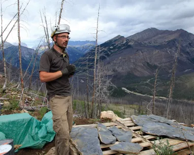 John Bernard posing for photo with mountain in the background
